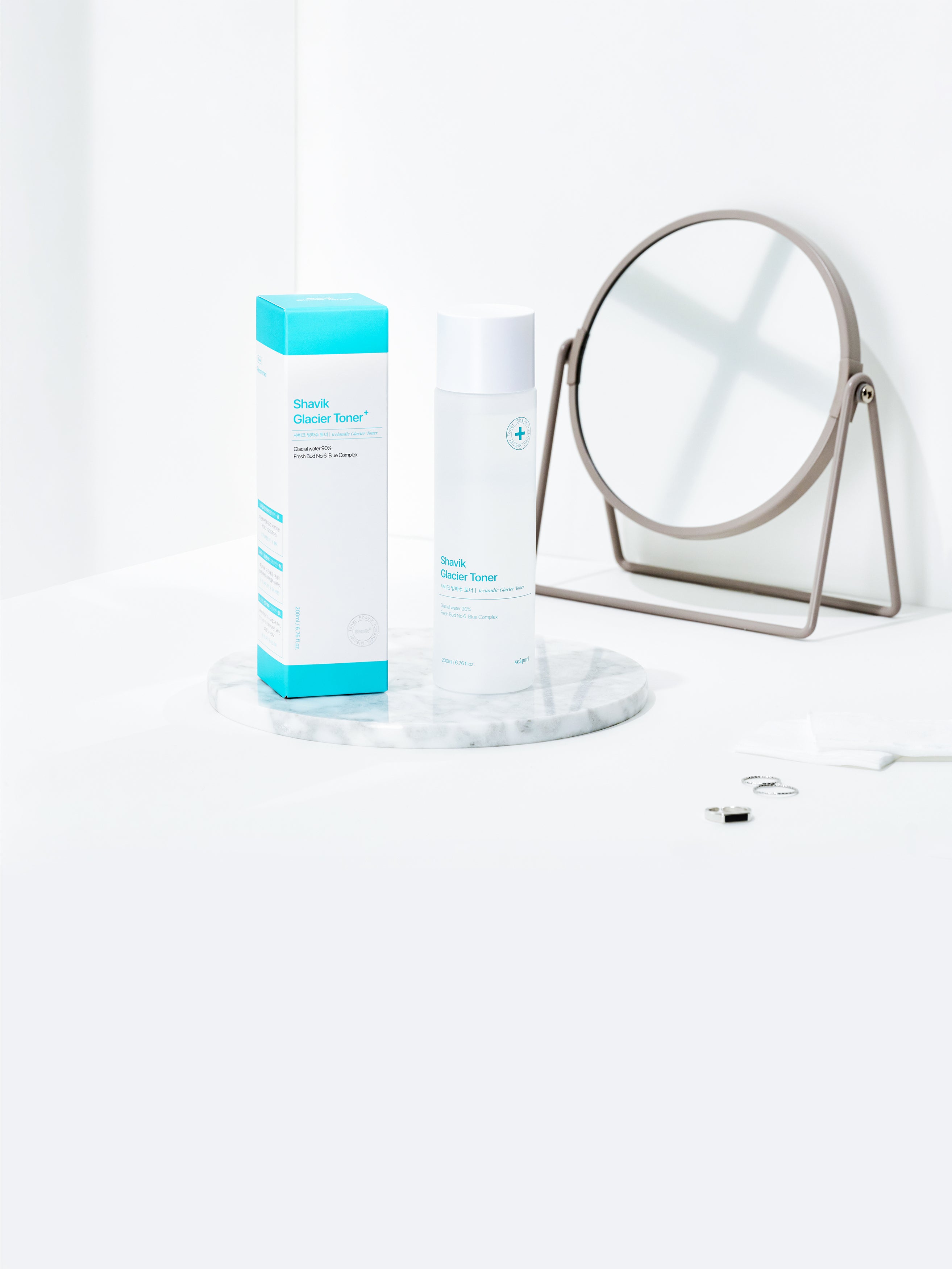 Shavik Glacier Toner bottle and packaging displayed on a marble tray beside a mirror, emphasizing a clean and refreshing skincare routine.